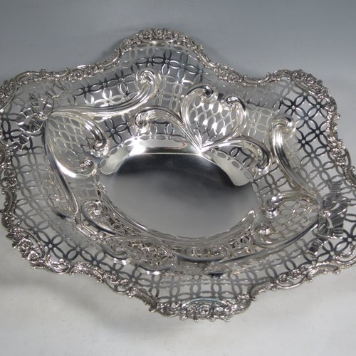 Antique Victorian sterling silver dish, having hand-pierced decoration with swags and bows, with a cast foliate border, and sitting on a matching cast foliate foot. Made by William Comyns of London in 1894. The dimensions of this fine hand-made silver table dish are length 36 cms (14.25 inches), width 28 cms (11 inches), height 10 cms (4 inches), and it weighs approx. 25 troy ounces (775g).