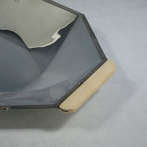 A Sterling Silver Art Deco dish, having an octagonal panelled body, with an applied ribbon & reed border together with two hand-cut bone handles, and sitting on a flat base. Made by Emile Viner of Sheffield in 1932. The dimensions of this fine hand-made Art Deco silver serving dish are length 30 cms (11.75 inches), width 18 cms (7 inches), height 3.5 cms (1.3 inches), and it weighs approx. 318g (10.3 troy ounces).