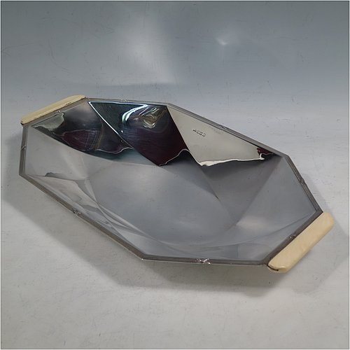 A Sterling Silver Art Deco dish, having an octagonal panelled body, with an applied ribbon & reed border together with two hand-cut bone handles, and sitting on a flat base. Made by Emile Viner of Sheffield in 1932. The dimensions of this fine hand-made Art Deco silver serving dish are length 30 cms (11.75 inches), width 18 cms (7 inches), height 3.5 cms (1.3 inches), and it weighs approx. 318g (10.3 troy ounces).