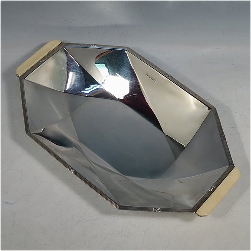 A Sterling Silver Art Deco dish, having an octagonal panelled body, with an applied ribbon & reed border together with two hand-cut bone handles, and sitting on a flat base. Made by Emile Viner of Sheffield in 1932. The dimensions of this fine hand-made Art Deco silver serving dish are length 30 cms (11.75 inches), width 18 cms (7 inches), height 3.5 cms (1.3 inches), and it weighs approx. 318g (10.3 troy ounces).