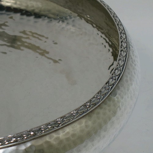 A very pretty Sterling Silver Arts and Crafts style table dish, having a round hand-hammered body, with an applied floral border, and sitting on a collet foot. Made by the Fenton Brothers Ltd., of London in 1922. The dimensions of this fine hand-made Arts and Crafts silver dish are diameter 22 cms (8.75 inches), height 7 cms (2.75 inches), and it weighs approx. 370g (12 troy ounces).