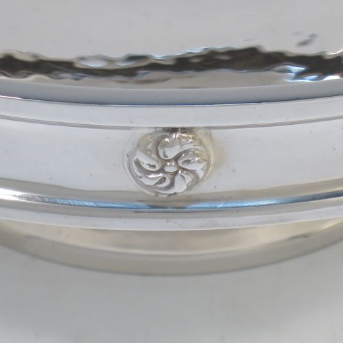 A very handsome and stylish Antique Sterling Silver Art and Crafts style dish, having a round body with hand-hammered decoration, a top border with applied round swirl motifs, and sitting on a low pedestal foot. Made by A. E. Jones of Birmingham in 1924. The dimensions of this fine hand-made Art and Crafts antique silver serving dish are diameter 20 cms (8 inches), height 7 cms (2.75 inches), and it weighs approx. 334g (10.8 troy ounces).