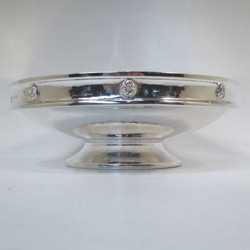 A very handsome and stylish Antique Sterling Silver Art and Crafts style dish, having a round body with hand-hammered decoration, a top border with applied round swirl motifs, and sitting on a low pedestal foot. Made by A. E. Jones of Birmingham in 1924. The dimensions of this fine hand-made Art and Crafts antique silver serving dish are diameter 20 cms (8 inches), height 7 cms (2.75 inches), and it weighs approx. 334g (10.8 troy ounces).