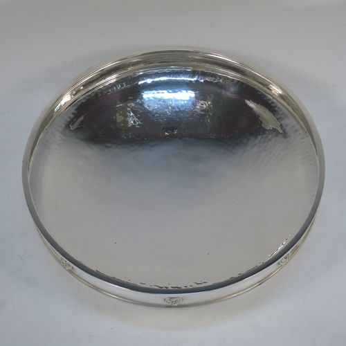 A very handsome and stylish Antique Sterling Silver Art and Crafts style dish, having a round body with hand-hammered decoration, a top border with applied round swirl motifs, and sitting on a low pedestal foot. Made by A. E. Jones of Birmingham in 1924. The dimensions of this fine hand-made Art and Crafts antique silver serving dish are diameter 20 cms (8 inches), height 7 cms (2.75 inches), and it weighs approx. 334g (10.8 troy ounces).