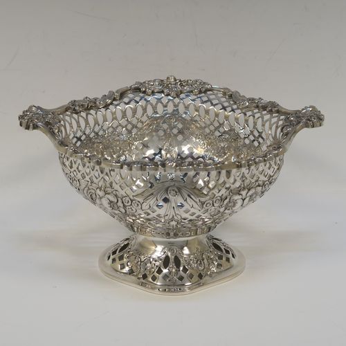 A very pretty pair of Antique Victorian Sterling Silver dishes, having oval bodies with neoclassical style decoration, hand-pierced with swags and bows and applied cast foliate borders, all sitting on matching oval pedestal feet. These beautiful antique silver dishes were made by Charles Stuart Harris of London in 1900. The dimensions of these fine hand-made silver table dishes are length 19 cms (7.5 inches), width 14 cms (5.5 inches), height 11 cms (4.3 inches), and they weigh a total of approx. 627g (20 troy ounces).
