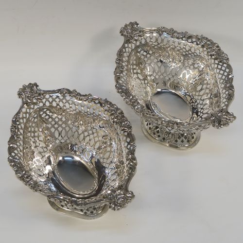 A very pretty pair of Antique Victorian Sterling Silver dishes, having oval bodies with neoclassical style decoration, hand-pierced with swags and bows and applied cast foliate borders, all sitting on matching oval pedestal feet. These beautiful antique silver dishes were made by Charles Stuart Harris of London in 1900. The dimensions of these fine hand-made silver table dishes are length 19 cms (7.5 inches), width 14 cms (5.5 inches), height 11 cms (4.3 inches), and they weigh a total of approx. 627g (20 troy ounces).