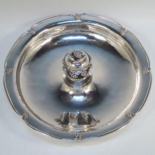 A very elegant and unusual Sterling Silver Arts and Crafts style large table fruit dish, having a round hand-hammered body, a central handle with cast grape and fruit decoration, and an applied grape border. Made by A. E. Jones of Birmingham in 1936. The dimensions of this fine hand-made silver fruit dish are diameter 31 cms (12.25 inches), height 10 cms (4 inches), and it weighs approx. 1,080g (34.8 troy ounces).