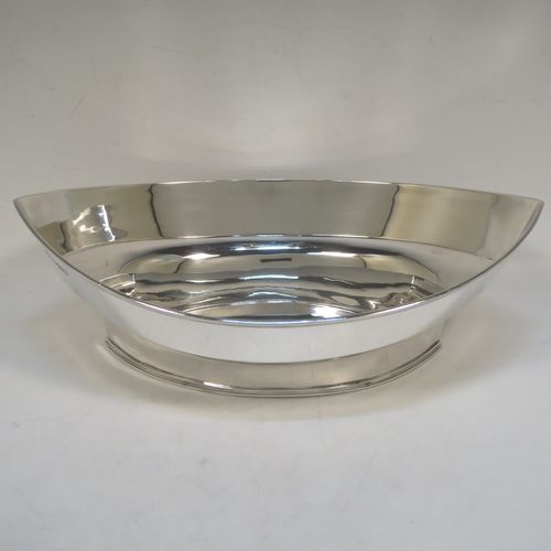 A very handsome Antique Edwardian Sterling Silver bread roll table dish, having a very plain oval boat-shaped body, with an applied reeded border, and all sitting on a flat base. This elegant antique silver bread dish was made by William Hutton of London in 1909. The dimensions of this fine hand-made antique silver bread-roll dish are length 28 cms (11 inches), width 17 cms (6.75 inches), height 9 cms (3.5 inches), and it weighs approx. 470g (15 troy ounces).