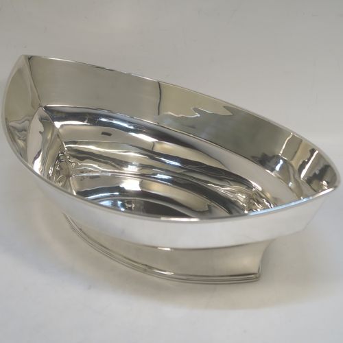 A very handsome Antique Edwardian Sterling Silver bread roll table dish, having a very plain oval boat-shaped body, with an applied reeded border, and all sitting on a flat base. This elegant antique silver bread dish was made by William Hutton of London in 1909. The dimensions of this fine hand-made antique silver bread-roll dish are length 28 cms (11 inches), width 17 cms (6.75 inches), height 9 cms (3.5 inches), and it weighs approx. 470g (15 troy ounces).