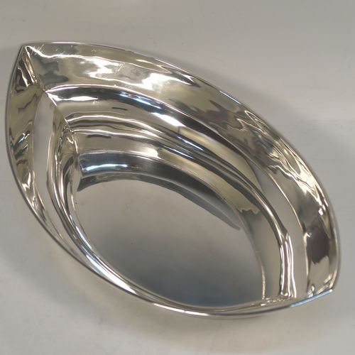 A very handsome Antique Edwardian Sterling Silver bread roll table dish, having a very plain oval boat-shaped body, with an applied reeded border, and all sitting on a flat base. This elegant antique silver bread dish was made by William Hutton of London in 1909. The dimensions of this fine hand-made antique silver bread-roll dish are length 28 cms (11 inches), width 17 cms (6.75 inches), height 9 cms (3.5 inches), and it weighs approx. 470g (15 troy ounces).