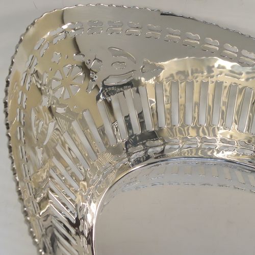 A very pretty Antique Sterling Silver bread roll table dish, having an oval body with hand-pierced geometrical and floral style decoration, an applied gadroon top border, and sitting on a flat base. This beautiful antique silver bread roll dish was made by the Barker Brothers of Chester in 1911. The dimensions of this fine hand-made silver bread dish are length 30 cms (11.75 inches), width 17.5 cms (7 inches), height 7.5 cms (3 inches), and it weighs approx. 389g (12.5 troy ounces).