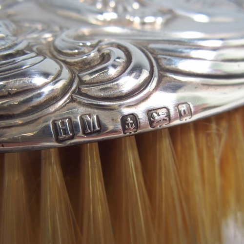 An Antique Edwardian Sterling silver Art Nouveau dressing table hair brush, having very pretty hand-chased floral and ribbon decoration, surrounding a figure of a lady. All with original bristles and wooden mount in very good condition. Made by Henry Miller of Birmingham in 1903. The dimensions of this fine hand-made hair brush are length 24 cms (9.5 inches), and width 9 cms (3.5 inches).