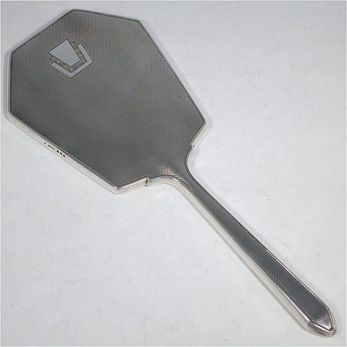 A Sterling Silver Art Deco style dressing table set with four pieces, consisting of a hand-mirror with original bevelled mirror, a clothes brush, a hair brush, all with original bristles, and an original comb, all with engine-turned decoration and vacant geometric Art Deco style cartouches. Made by the Daniel Manufacturing Co., of Birmingham in 1949. The dimensions of this fine hand-made sterling silver dressing table service are length of mirror 27 cms (10.5 inches), length of hair brush 22 cms (8.75 inches), and length of clothes brush 13.5 cms (5.3 inches).