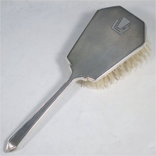 A Sterling Silver Art Deco style dressing table set with four pieces, consisting of a hand-mirror with original bevelled mirror, a clothes brush, a hair brush, all with original bristles, and an original comb, all with engine-turned decoration and vacant geometric Art Deco style cartouches. Made by the Daniel Manufacturing Co., of Birmingham in 1949. The dimensions of this fine hand-made sterling silver dressing table service are length of mirror 27 cms (10.5 inches), length of hair brush 22 cms (8.75 inches), and length of clothes brush 13.5 cms (5.3 inches).
