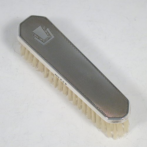 A Sterling Silver Art Deco style dressing table set with four pieces, consisting of a hand-mirror with original bevelled mirror, a clothes brush, a hair brush, all with original bristles, and an original comb, all with engine-turned decoration and vacant geometric Art Deco style cartouches. Made by the Daniel Manufacturing Co., of Birmingham in 1949. The dimensions of this fine hand-made sterling silver dressing table service are length of mirror 27 cms (10.5 inches), length of hair brush 22 cms (8.75 inches), and length of clothes brush 13.5 cms (5.3 inches).