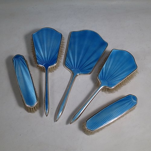 A Sterling Silver and light blue enamelled Art Deco style dressing table set with five pieces, consisting of a hand-mirror with original bevelled mirror, two clothes brushes, and two hair brushes, all with original bristles, and all in their original black velvet and cream satin-lined presentation box. Made by W. G. Sothers Ltd., of Birmingham in 1931. The dimensions of this fine hand-made sterling silver and enamelled dressing table service are length of hand mirror 26.5 cms (10.5 inches), length of hair brush 23.5 cms (9.25 inches), and length of clothes brush 14.5 cms (5.75 inches).