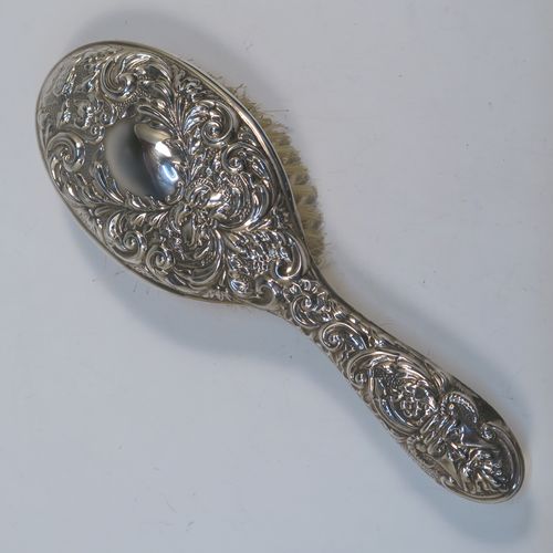 A very pretty Sterling Silver four-piece dressing table, consisting of a hand-mirror with a bevelled mirror, a hair brush, a clothes brush, and a hand comb, all hand-chased with floral and scroll decoration, with nylon bristles, and in their original cream satin-lined and blue presentation box. This beautiful silver dressing table set was made in Birmingham in 2002. The dimensions of this fine hand-made sterling silver dressing table service are length of hand mirror 24 cms (9.5 inches), length of hair brush 23 cms (9 inches), and length of clothes brush 15 cms (6 inches).