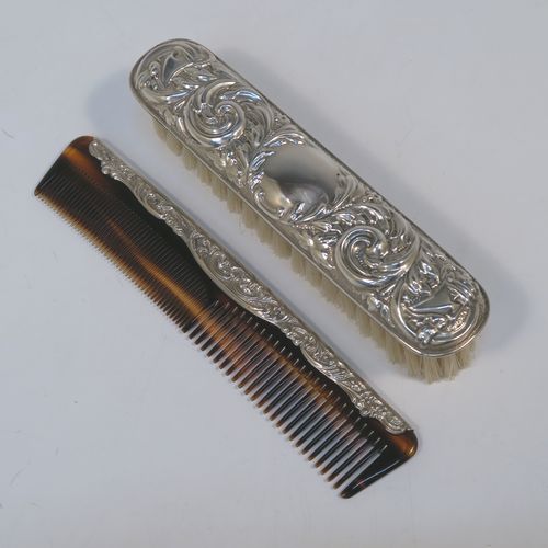 A very pretty Sterling Silver four-piece dressing table, consisting of a hand-mirror with a bevelled mirror, a hair brush, a clothes brush, and a hand comb, all hand-chased with floral and scroll decoration, with nylon bristles, and in their original cream satin-lined and blue presentation box. This beautiful silver dressing table set was made in Birmingham in 2002. The dimensions of this fine hand-made sterling silver dressing table service are length of hand mirror 24 cms (9.5 inches), length of hair brush 23 cms (9 inches), and length of clothes brush 15 cms (6 inches).