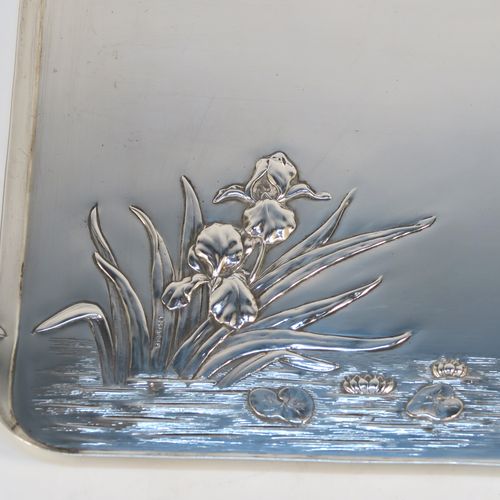 A very pretty Antique Edwardian Sterling Silver Art Nouveau style dressing table pin tray, having a rectangular body with a hand-chased area of lilies and pads in a flowing river, a raised plain outer border, and all sitting on a flat base. This beautiful antique silver dressing table tray was made by William Comyns of London in 1906. The dimensions of this fine hand-made antique silver pin tray are length 27 cms (10.5 inches), width 18.5 cms (7.25 inches), and it weighs approx. 365g (11.8 troy ounces).   