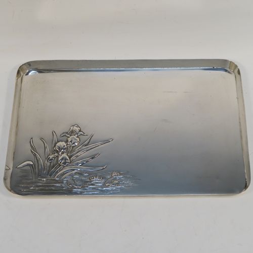 A very pretty Antique Edwardian Sterling Silver Art Nouveau style dressing table pin tray, having a rectangular body with a hand-chased area of lilies and pads in a flowing river, a raised plain outer border, and all sitting on a flat base. This beautiful antique silver dressing table tray was made by William Comyns of London in 1906. The dimensions of this fine hand-made antique silver pin tray are length 27 cms (10.5 inches), width 18.5 cms (7.25 inches), and it weighs approx. 365g (11.8 troy ounces).   
