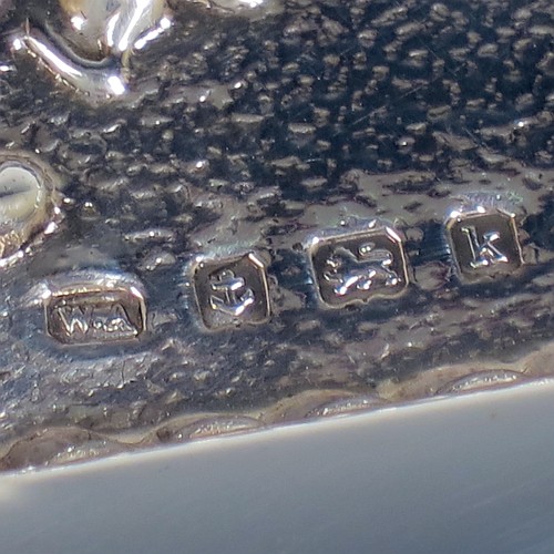 An Antique Edwardian Sterling Silver dressing table pin tray, having a rectangular body with a raised fluted border, hand-chased floral and scroll decoration on a hand-hammered ground, with a central vacant cartouche, and all sitting on a flat base. Made by William Aitken of Birmingham in 1909. The dimensions of this fine hand-made antique silver pin or dressing table tray are length 27 cms (10.5 inches), width 19 cms (7.5 inches), and it weighs approx. 216g (7 troy ounces).
