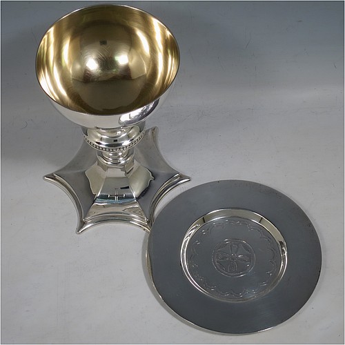 A Sterling Silver altar chalice and paten, having a plain round tapering cup with gold-gilt interior, a round column with a middle baluster and bead border, and a spreading hexagonal pedestal foot, together with a plain round paten with hand-engraved cross. The chalice made by Frederick Osborne of London in 1931, and the paten by Jones and Willis of London in 1908. The dimensions of this fine hand-made silver chalice & paten are height 15 cms (6 inches), diameter of cup 10 cms (4 inches), diameter of paten 13.5 cms (5.3 inches), and it weighs a total of 455g (14.7 troy ounces).