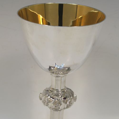 A large and handsome Sterling Silver altar chalice having a hand-hammered or planished finish, with a round tapering cup and a gold-gilt interior, an octagonal panelled stem with a central applied jewel-like baluster, and all sitting on a spreading octagonal panelled base with an applied fleur-de-lis border. This beautiful and impressive silver altar chalice was made made by A. R. Mowbray and Co., Ltd., of London in 1948. The dimensions of this fine hand-made silver chalice are height 20 cms (8 inches), diameter at lip of cup 10 cms (4 inches), spread across base 15 cms (6 inches), and it weighs approx. 444g (14.3 troy ounces).
