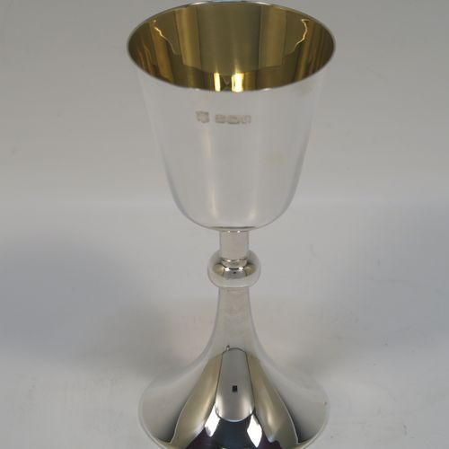 An elegant Antique Sterling Silver travelling communion chalice, having a plain round tapering cup with a gold-gilt interior, a round column with a middle baluster, and a spreading round pedestal foot, together with a matching plain round paten. The chalice was made by the Dixon Brothers of Sheffield in 1911, whilst the paten was made by A. E. Jones of Sheffield in 1962. The dimensions of this fine hand-made antique silver chalice & paten are height of chalice 12 cms (4.75 inches), diameter of paten 10 cms (4 inches), and the total weight is 137g (4.4 troy ounces).