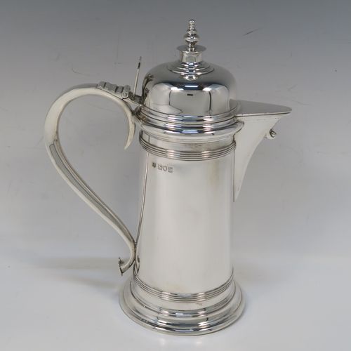 A handsome Antique Victorian Sterling Silver ecclesiastical wine flagon ewer, having a round straight-sided body and applied reeded bands, a side scroll handle, together with a hinged domed lid and cast round finial, a covered sparrow-beak spout, and sitting on a spreading collet foot. This elegant silver church consecrated wine flagon was made by William Gibson and John Langland of London in 1899. The dimensions of this fine hand-made antique silver flagon or ewer are height 24 cms (9.5 inches), diameter at base 11 cms (4.25 inches), and it weighs approx. 677g (21.8 troy ounces).   