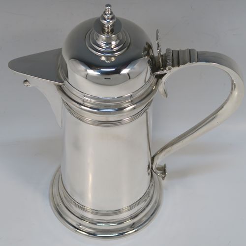 A handsome Antique Victorian Sterling Silver ecclesiastical wine flagon ewer, having a round straight-sided body and applied reeded bands, a side scroll handle, together with a hinged domed lid and cast round finial, a covered sparrow-beak spout, and sitting on a spreading collet foot. This elegant silver church consecrated wine flagon was made by William Gibson and John Langland of London in 1899. The dimensions of this fine hand-made antique silver flagon or ewer are height 24 cms (9.5 inches), diameter at base 11 cms (4.25 inches), and it weighs approx. 677g (21.8 troy ounces).