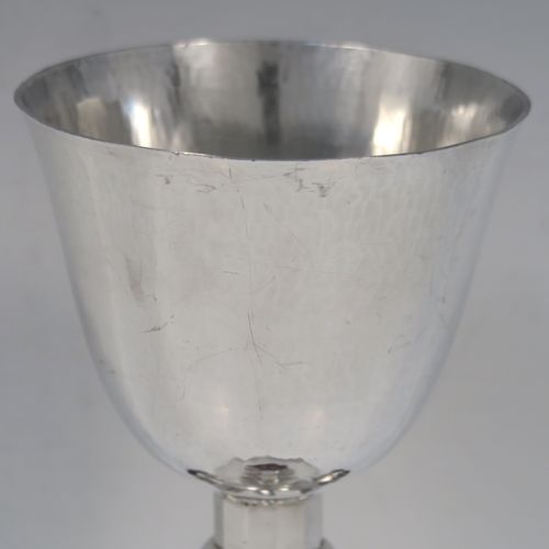 A very stylish Art Deco Sterling Silver altar chalice having a round hand-hammered or planished tapering cup, a panelled stem with four central applied red garnet coloured cabochon jewels, and all sitting on a spreading octagonal panelled base. This beautiful silver altar chalice was made made by J L A of London in 1936. The dimensions of this fine hand-made Art Deco silver chalice are height 21 cms (8.25 inches), diameter at lip of cup 8.5 cms (3.3 inches), spread across base 11 cms (4.3 inches), and it weighs approx. 365g (11.7 troy ounces).
