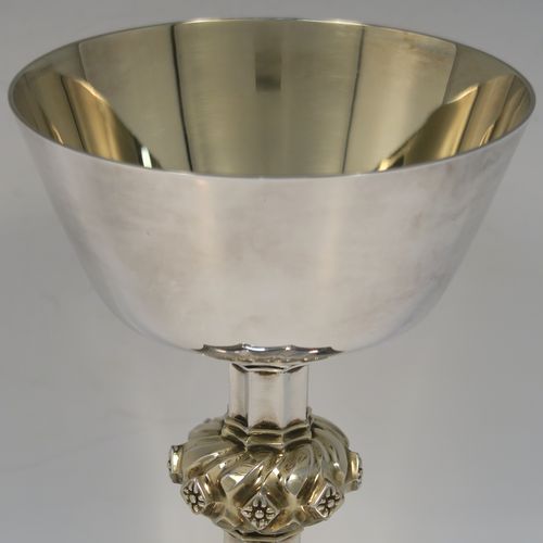 A large and handsome Sterling Silver altar chalice, with a round tapering cup and a gold-gilt interior, an octagonal panelled stem with a central applied jewel-like baluster (which is also gold-gilt), and all sitting on a spreading octagonal panelled base with an applied gold-gilt cross-style border. This beautiful silver altar chalice was made made by Vanpoulles of London in 1975. The dimensions of this fine hand-made silver chalice are height 18 cms (7 inches), diameter at lip of cup 11 cms (4.3 inches), spread across foot 13 cms (5 inches), and it weighs approx. 412g (13.3 troy ounces).