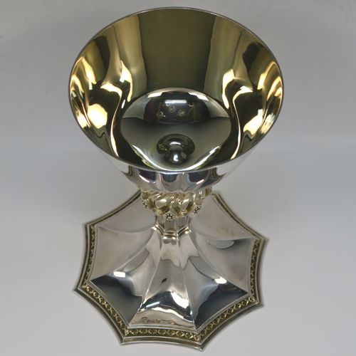 A large and handsome Sterling Silver altar chalice, with a round tapering cup and a gold-gilt interior, an octagonal panelled stem with a central applied jewel-like baluster (which is also gold-gilt), and all sitting on a spreading octagonal panelled base with an applied gold-gilt cross-style border. This beautiful silver altar chalice was made made by Vanpoulles of London in 1975. The dimensions of this fine hand-made silver chalice are height 18 cms (7 inches), diameter at lip of cup 11 cms (4.3 inches), spread across foot 13 cms (5 inches), and it weighs approx. 412g (13.3 troy ounces).