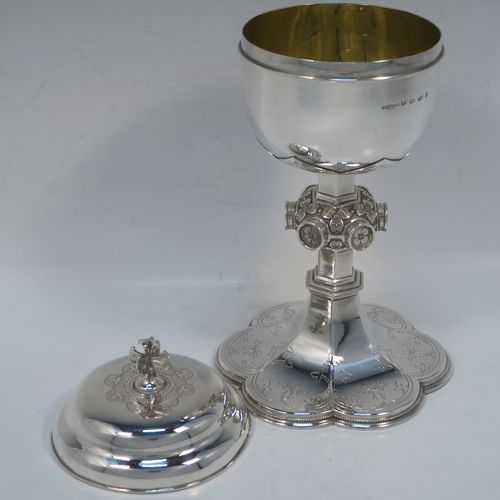 A beautiful Antique Victorian Sterling Silver Ciborium, having a plain round bellied body and a gold-gilt interior, sitting on a pedestal foot with a central applied jewel-like and floral baluster and a hand-engraved hexafoil foot with an applied bead-edged border, and a domed lift-off lid with cruciform finial and hand-engraved decoration. This wonderful silver ciborium was made by John Hardman and Co., of Birmingham in 1874. The dimensions of this fine hand-made antique silver ciborium are height 21.5 cms (8.5 inches), diameter of cup 9 cms (3.5 inches), and it weighs approx. 393g (12.6 troy ounces).