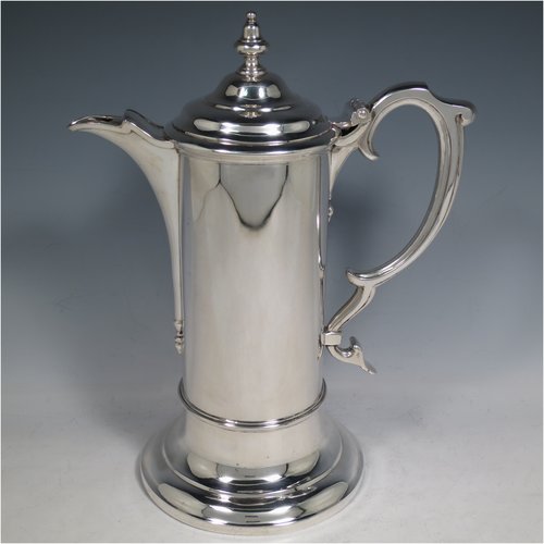 An Antique Victorian Sterling Silver communion service composed of a flagon and two goblets. The flagon in an early 17th century style having a straight-sided body, a scroll handle, a hinged & domed lid with urn-shaped finial, a matching scrolled spout and sitting on a collet foot. Together with a pair of plain round baluster goblets with gold-gilt interiors. All made by Robert Garrard of London in 1862/63. The dimensions of this fine hand-made communion set are height of flagon 29 cms (11.5 inches), length across handle & spout 23 cms (9 inches), height of goblets 18 cms (7 inches), and with a total weight of approx. 1,643g (53 troy ounces).
