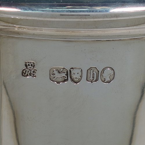 An Antique Victorian Sterling Silver communion flagon for wine, in an early 17th century style having a straight-sided body, a scroll handle, a hinged & domed lid with urn-shaped finial, a matching scrolled spout and sitting on a collet foot. Made by Robert Garrard of London in 1863. The dimensions of this fine hand-made communion flagon are height 29 cms (11.5 inches), length across handle & spout 23 cms (9 inches),and it weighs approx. 1,092g (35 troy ounces).