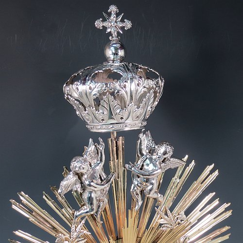 An Antique Victorian Sterling Silver and gold-gilt Belgian Monstrance, for holding the consecrated host, with crown finial above two cast cherub figures, a sun-burst relic Luna holder with two cast angel figures below, and sitting on a hand-chased oval shaped pedestal foot. Made by M. Decury of Belgium between 1831 and 1868. The dimensions of this fine hand-made antique silver Monstrance are height 71 cms (28 inches), depth 15 cms (6 inches), and width 33 cms (13 inches), with a total weight of approx. 97 troy ounces (3,000g).