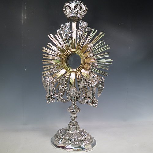 An Antique Victorian Sterling Silver and gold-gilt Belgian Monstrance, for holding the consecrated host, with crown finial above two cast cherub figures, a sun-burst relic Luna holder with two cast angel figures below, and sitting on a hand-chased oval shaped pedestal foot. Made by M. Decury of Belgium between 1831 and 1868. The dimensions of this fine hand-made antique silver Monstrance are height 71 cms (28 inches), depth 15 cms (6 inches), and width 33 cms (13 inches), with a total weight of approx. 97 troy ounces (3,000g).