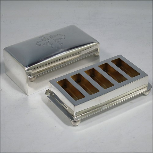 A Sterling Silver wafer box, having a plain rectangular body with rounded corners, a lift-off lid with a hand-engraved Christogram, covering a holder with five slots for wafers, and sitting on an applied base with four ball feet. Made by A. R. Mowbray & Co. Ltd., of London in 1946. The dimensions of this fine hand-made silver wafer box are length 9.5 cms (3.75 inches), depth 6 cms (2.25 inches), height 4.5 cms (1.75 inches), and it weighs approx. 211g (6.8 troy ounces).