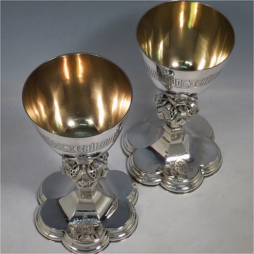 An Antique Victorian Sterling Silver pair of altar chalices, having plain round tapering cups with gold-gilt interiors and bands of hand-engraved Latin inscriptions, middle balusters with hand-chased work made to look as if mounted with six jewels, and sitting on spreading hexafoil feet with engraved Christograms. Made by Edward Dimes of London in 1893. The dimensions of this fine pair of hand-made antique silver chalices are height 20 cms (8 inches), width at base 13 cms (5 inches), and they weigh a total of approx. 778g (25 troy ounces).