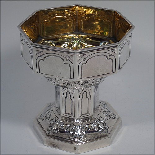 An Antique Victorian Sterling Silver very rare and unusual travelling chalice, in the shape of an octagonal shaped baptismal font, the top piece, which screws into the base, having a gold-gilt interior and hand-chased panels with anthemion leaves and angel faces, the pedestal base with matching panel work and leaves, and all in its original dark-blue satin and velvet-lined presentation box. Made by George Fox of London in 1863. The dimensions of this fine hand-made antique silver travelling chalice are height 10 cms (4 inches), diameter at top 9 cms (3.5 inches), with a total weight of approx. 172g (5.5 troy ounces).
