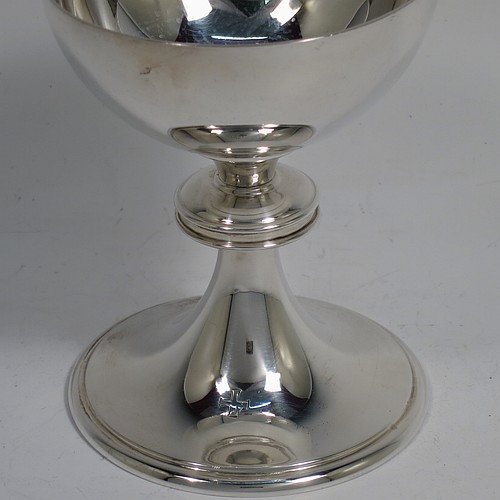 A small Sterling Silver altar chalice and paten, having a plain round bellied cup, a round column with a middle baluster, and a spreading round pedestal foot with reeded borders, together with a plain round original paten. Made by H. F. and Co. Ltd. of London in 1965. The dimensions of this fine hand-made silver chalice and paten are height 10 cms (4 inches), diameter of paten 11 cms (4.25 inches), with a total weight of approx. 203g (6.5 troy ounces).