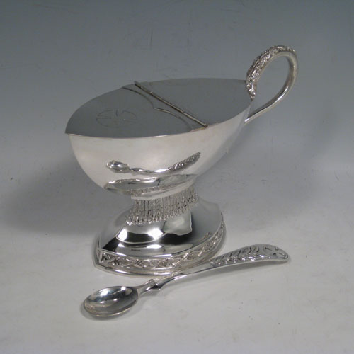 Sterling silver incense boat and spoon, having an oval plain body, a hinged half-lid, a cast scroll handle, sitting on a pedestal foot with hand-chased floral decoration. Together with a hand-chased spoon with pierced handle. All made in London in 1970. The dimensions of this fine silver incense boat are height 13 cms (5 inches), length 19 cms (7.5 inches), and width 8 cms (3 inches). With a total weight of 400g (13 troy ounces).