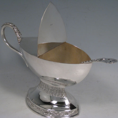 Sterling silver incense boat and spoon, having an oval plain body, a hinged half-lid, a cast scroll handle, sitting on a pedestal foot with hand-chased floral decoration. Together with a hand-chased spoon with pierced handle. All made in London in 1970. The dimensions of this fine silver incense boat are height 13 cms (5 inches), length 19 cms (7.5 inches), and width 8 cms (3 inches). With a total weight of 400g (13 troy ounces).