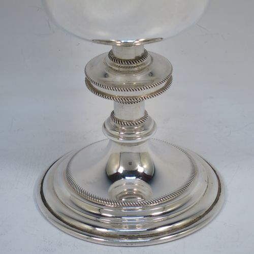 A handsome Sterling Silver Ciborium, having a plain round body with applied rope-twist borders and a gold-gilt interior, sitting on a matching pedestal foot with central baluster, and a lift-off lid with cruciform finial. Made by Vanpoulles Ltd. of London in 1962. The dimensions of this fine hand-made silver ciborium are height 19 cms (7.5 inches), diameter of cup 8.5 cms (3.3 inches), and the cup weighs approx. 264g (8.5 troy ounces).