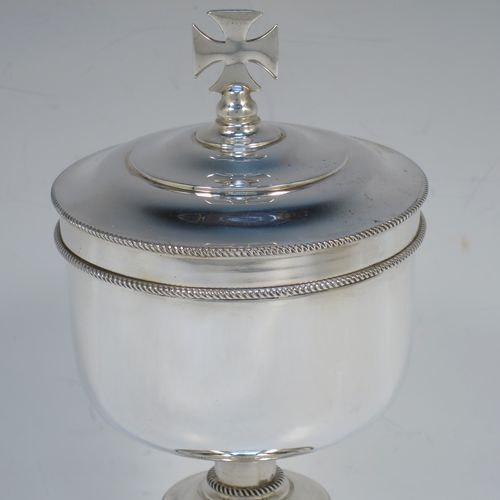 A handsome Sterling Silver Ciborium, having a plain round body with applied rope-twist borders and a gold-gilt interior, sitting on a matching pedestal foot with central baluster, and a lift-off lid with cruciform finial. Made by Vanpoulles Ltd. of London in 1962. The dimensions of this fine hand-made silver ciborium are height 19 cms (7.5 inches), diameter of cup 8.5 cms (3.3 inches), and the cup weighs approx. 264g (8.5 troy ounces).