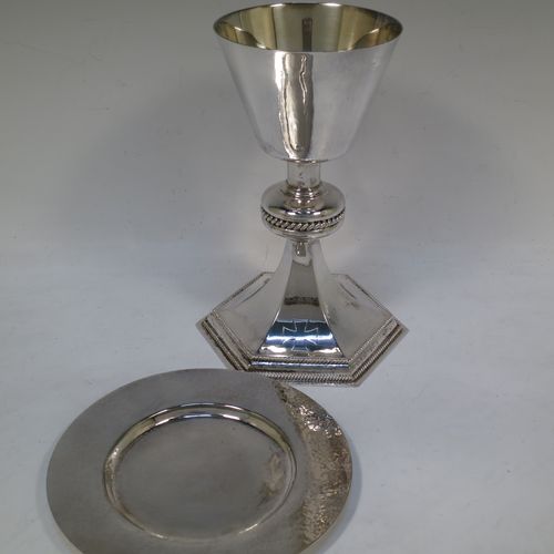 A very handsome Sterling Silver altar chalice and paten, having a round hand-hammered tapering cup with a gold-gilt interior, a middle baluster with an applied gadroon band, and a spreading hexagonal pedestal foot with applied double gadroon borders, and the paten with matching hand-hammered decoration. Made by Hurst, Franklin and Co. Ltd., of London in 1956. The dimensions of this fine hand-made silver chalice and paten are height 20 cms (8 inches), width at base 13.5 cms (5.5 inches), diameter of paten 15 cms (6 inches), and it weighs approx. 326g (10.5 troy ounces).