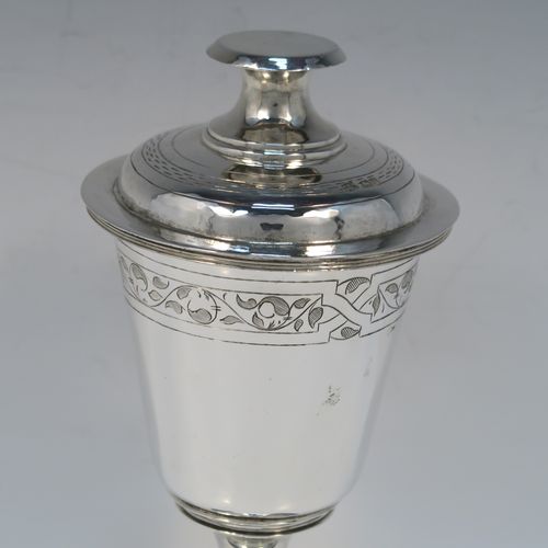 A very handsome Antique Sterling Silver altar chalice and cover, in a post-Reformation communion cup style, having a plain round tapering cup with a top band of floral hand-engraved decoration, a lift-off lid with flat finial, all sitting on a round stepped pedestal foot with a middle baluster. This beautiful silver chalice cup and cover were made by Herbert and Frank Barker of Chester in 1915. The dimensions of this fine hand-made silver communion cup and cover are height 21 cms (8.25 inches), diameter 9 cms (3.5 inches), and with a total weight of approx. 343g (11 troy ounces).   