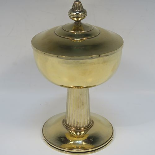 A very beautiful and stylish Sterling Silver and Gold-Gilt Ciborium, having a round body with a hand-hammered or planished finish, sitting on a round pedestal foot base with a hand-chased and panelled column, and a lift-off lid with urn-shaped finial. This beautiful Arts and Crafts style silver ciborium was made by George Hart for the Guild of Handicrafts in London 1953. The dimensions of this fine hand-made silver and gold-gilt ciborium are height 19 cms (7.5 inches), diameter of cup 11.5 cms (4.5 inches), and it weighs a total of approx. 620g (20 troy ounces).   