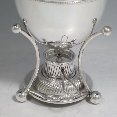 Antique Edwardian silver-plated egg coddler, having a plain round body, with lift-off lid having swirl fluting and a flame finial, and internal holder for four eggs, attached to a frame and stand with an original burner, all sitting on three ball feet. Made by Welbeck & Co., in ca. 1900. The dimensions of this fine hand-made silver plated egg coddler are height 23.5 cms (9.25 inches), and diameter 11 cms (4.3 inches).